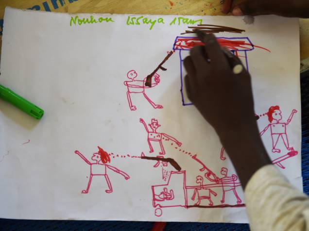 Jovens refugiados desenham cenas de ataque durante programa de terapia da UNICEF, próximo a Baga Sola Jovens refugiados desenham cenas de ataque durante programa de terapia da UNICEF, próximo a Baga Sola