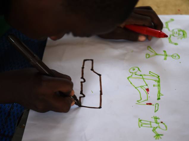 Jovens refugiados desenham cenas de ataque durante programa de terapia da UNICEF, próximo a Baga Sola Jovens refugiados desenham cenas de ataque durante programa de terapia da UNICEF, próximo a Baga Sola