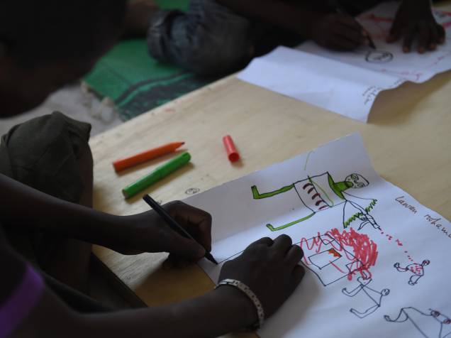 Jovens refugiados desenham cenas de ataque durante programa de terapia da UNICEF, próximo a Baga Sola Jovens refugiados desenham cenas de ataque durante programa de terapia da UNICEF, próximo a Baga Sola