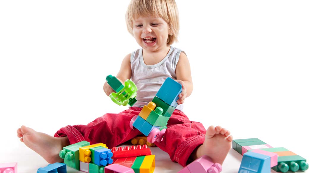 Menino brincando com blocos coloridos