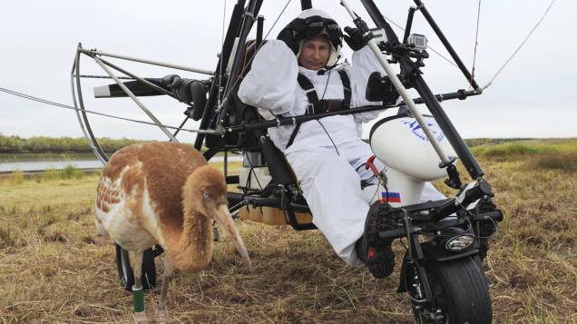 O presidente russo, Vladimir Putin, se senta em um deltaplano motorizado perto de uma cegonha no distrito de Yamalo-Nenets O presidente russo, Vladimir Putin, se senta em um deltaplano motorizado perto de uma cegonha no distrito de Yamalo-Nenets