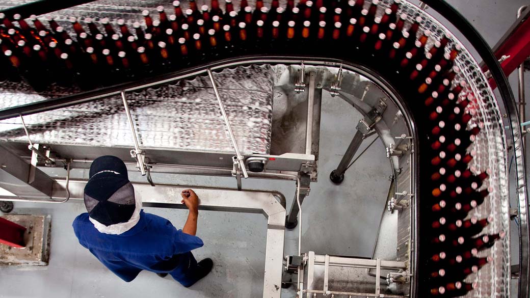 Funcionário na linha de produção da fábrica da AmBev, em Minas Gerais