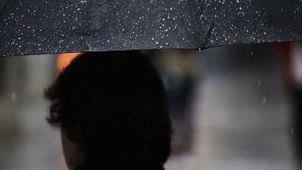 Pessoas se protegem da chuva em São Paulo: cena não se repete há 41 dias