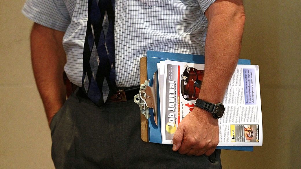 Desempregado americano carrega publicação com ofertas de postos de trabalho
