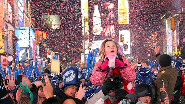 Garota observa bola luminosa descer por poste a anunicar a chegada de 2013 em Nova York