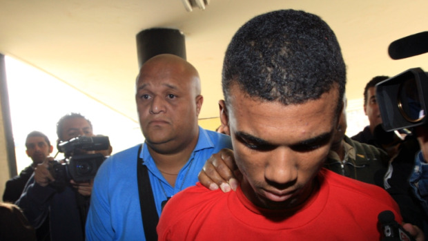 S&eacute;rgio Rosa Sales &eacute; conduzido por policiais da carceragem para a sala onde acontece a acarea&ccedil;&atilde;o, em Belo Horizonte.