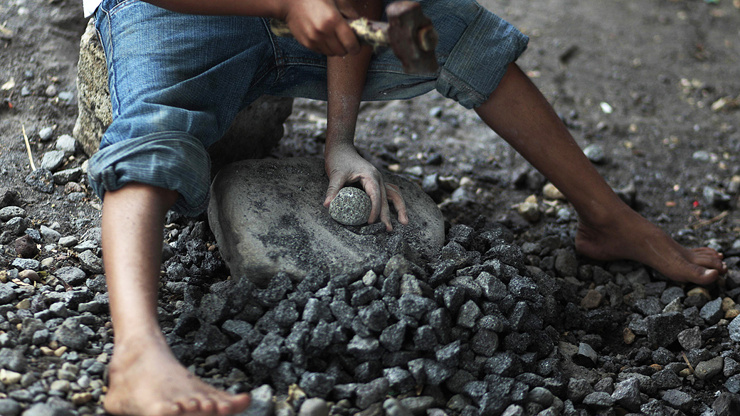 Menino de 9 anos usa martelo para quebrar pedras em estrada para Mazatenango, na Guatemala. O Dia Mundial Contra o Trabalho Infantil é comemorado nesta terça-feira