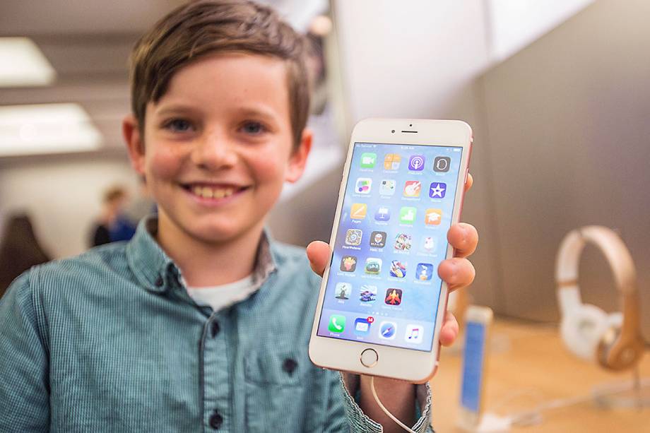 Menino mostra um iPhone 6s Plus, em uma loja da Apple na Austrália Menino mostra um iPhone 6s Plus, em uma loja da Apple na Austrália