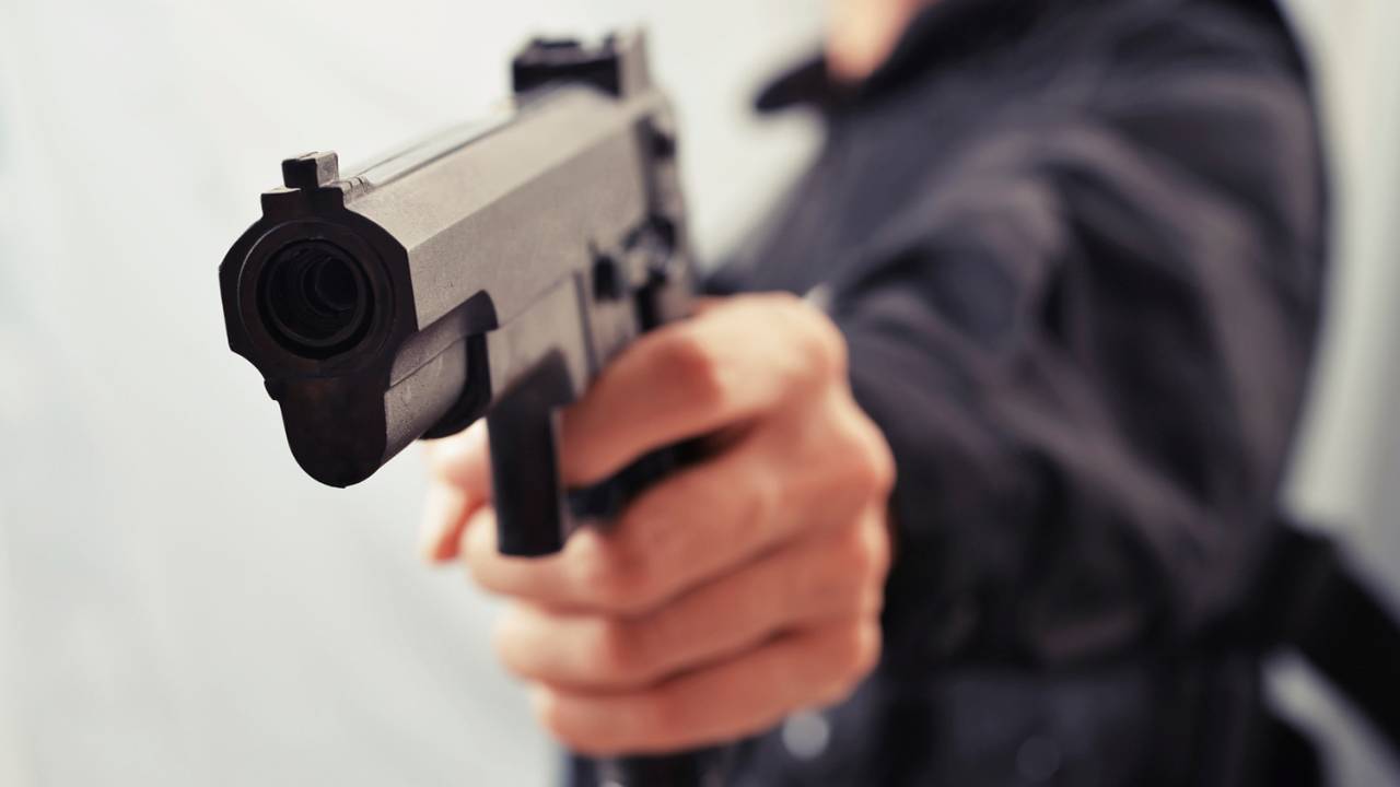 Homem atirando com uma pistola