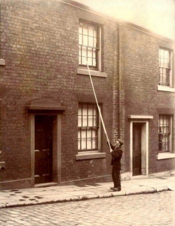 Homem-despertador, contratado para acordar as pessoas batendo nas janelas (1900)