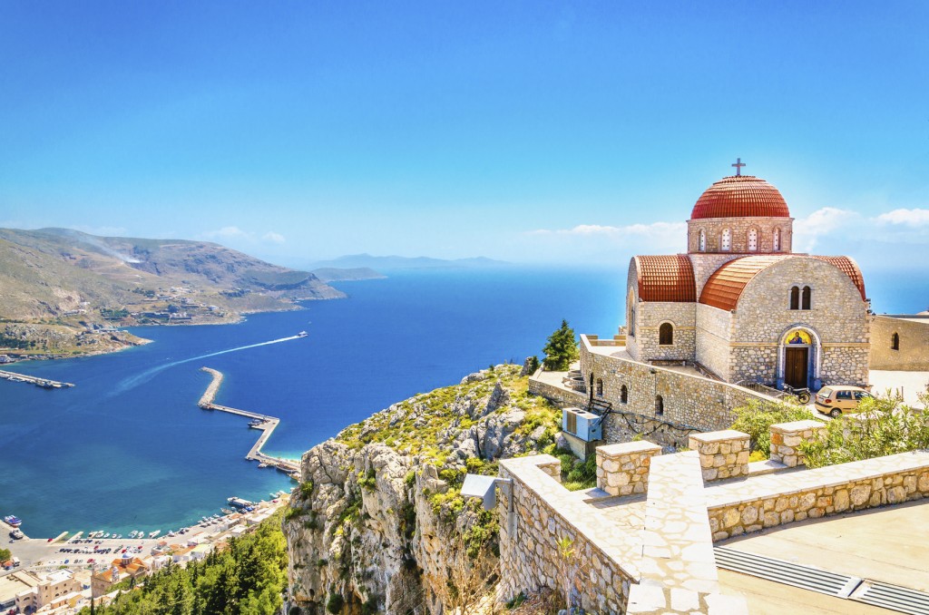 Remote church with red roofing on cliff, Greece