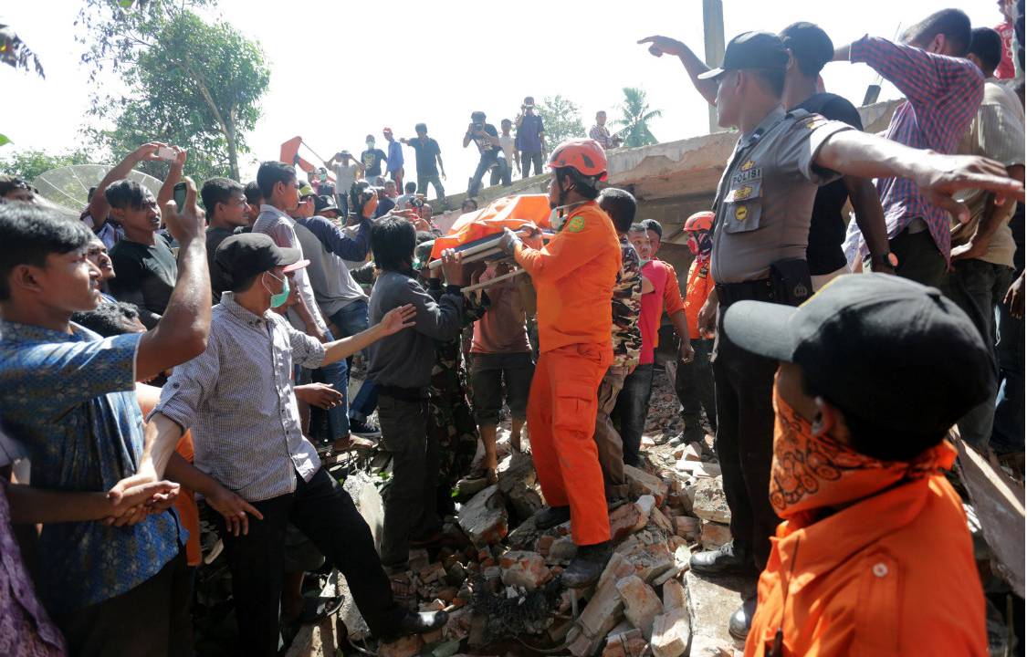Bombeiros e civis socorrem as vítimas do terremoto na Indonésia