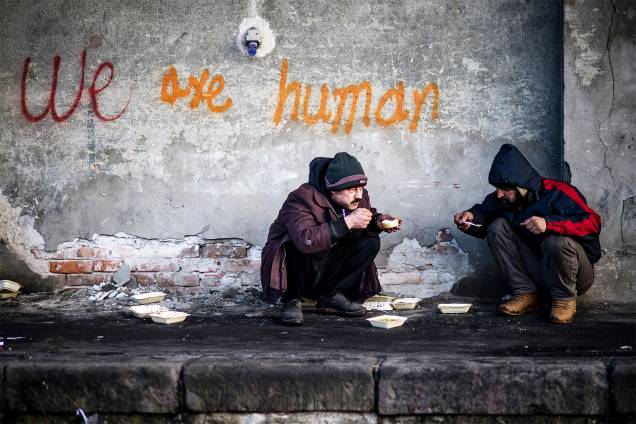 Migrantes se alimentam em um armazém abandonado de Belgrado, na Sérvia - 15/01/2017 Migrantes se alimentam em um armazém abandonado de Belgrado, na Sérvia - 15/01/2017