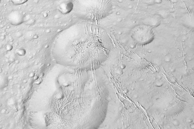 A sonda Cassini da Nasa mostra as crateras da lua Enceladus de Saturno durante voo rasante A sonda Cassini da Nasa mostra as crateras da lua Enceladus de Saturno durante voo rasante