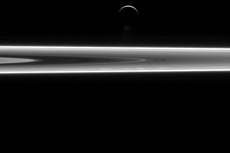 Foto tirada pela missão Cassini, da Nasa, mostra a lua Enceladus acima dos aneis de Saturno