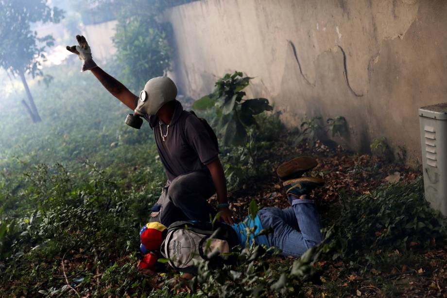 Manifestante ferido é ajudado por outro após confronto com a polícia durante a chamada 'mãe de todas as marchas' contra o presidente da Venezuela, Nicolás Maduro, em Caracas - 19/04/2017