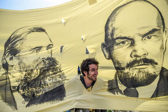 A man looks through the hole picturing German philosopher and communist thinker Friedrich Engels (L) and Soviet leader Vladimir Ilitch Lenin while he takes part in gather in Bakirkoy district as part of the the May Day rally, in Istanbul, on May 1, 2017. / AFP PHOTO / OZAN KOSE A man looks through the hole picturing German philosopher and communist thinker Friedrich Engels (L) and Soviet leader Vladimir Ilitch Lenin while he takes part in gather in Bakirkoy district as part of the the May Day rally, in Istanbul, on May 1, 2017. / AFP PHOTO / OZAN KOSE