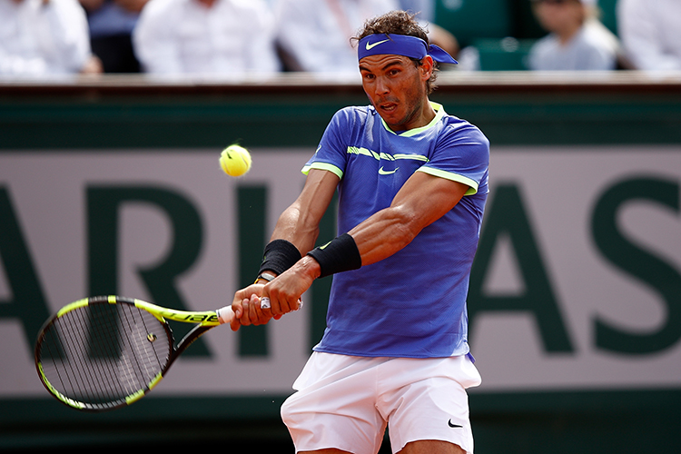 Tenista espanhol Rafael Nadal devolve a bola para o holandês Robin Haase, durante quarto dia de Roland Garros, em Paris, França
