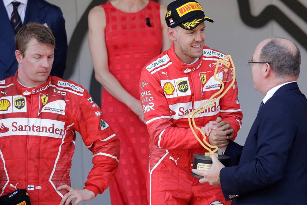O piloto da Ferrari Sebastian Vettel recebe o trof&eacute;u ap&oacute;s superar o companheiro Kimi Raikkonen e vencer o GP de M&ocirc;naco