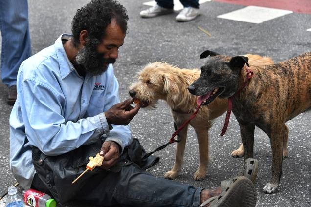 Morador de rua alimenta seus cães na Avenida Paulista, enquanto centrais sindicai fazem ato do Dia do Trabalho, em São Paulo Morador de rua alimenta seus cães na Avenida Paulista, enquanto centrais sindicai fazem ato do Dia do Trabalho, em São Paulo