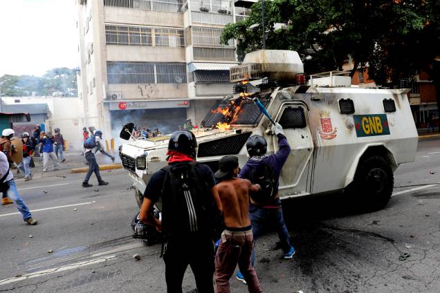 Manifestantes da oposição ao Presidente Nicolás Maduro atacam furgão da polícia durante confronto no protesto em Caracas, na Venezuela - 03/05/2017 Manifestantes da oposição ao Presidente Nicolás Maduro atacam furgão da polícia durante confronto no protesto em Caracas, na Venezuela - 03/05/2017