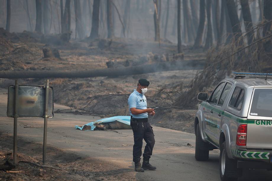 Policial chama reforços para retirada de corpos, vítimas do incêndio que atingiu a região de Bouca, em Portugal - 18/06/2017