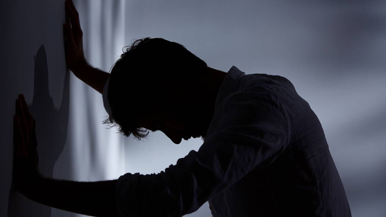 Mãos de homem inclinada contra a parede