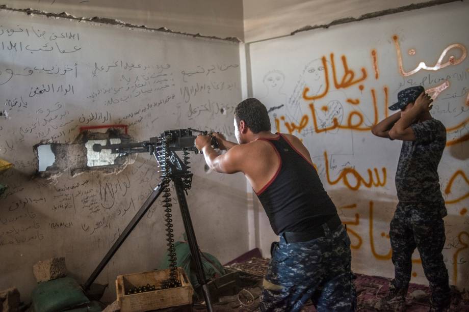 Um policial federal do Iraque dispara uma metralhadora .50 contra militantes do Estado Islâmico, em Bab Jded, no oeste de Mosul.