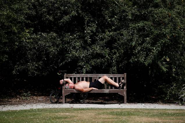 Homem deitado em um banco de um parque de Londres descansa sob o sol durante as altas temperaturas do verão europeu - 21/06/2017 Homem deitado em um banco de um parque de Londres descansa sob o sol durante as altas temperaturas do verão europeu - 21/06/2017