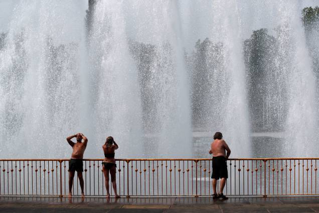 Pessoas desfrutam da água na fonte do parque Battersea, em Londres, para se refrescar durante a onda de calor na europa - 21/06/2017 Pessoas desfrutam da água na fonte do parque Battersea, em Londres, para se refrescar durante a onda de calor na europa - 21/06/2017