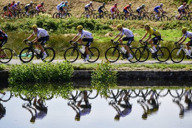 Ciclistas são refletidos em um lago enquanto disputavam a quarta etapa do Tour de France de 160,5 km entre Vittel e La Planche des Belles Filles, na França - 5 de julho de 2017 Ciclistas são refletidos em um lago enquanto disputavam a quarta etapa do Tour de France de 160,5 km entre Vittel e La Planche des Belles Filles, na França - 5 de julho de 2017
