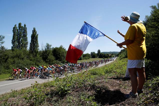 Torcedor segura bandeira da França enquanto o pelotão participa da etapa 6 de 216 km de Vesoul para Troyes, do Le Tour de France - 6 de julho de 2017 Torcedor segura bandeira da França enquanto o pelotão participa da etapa 6 de 216 km de Vesoul para Troyes, do Le Tour de France - 6 de julho de 2017