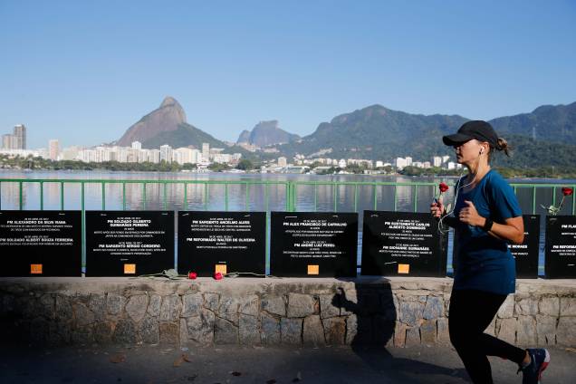 Mulher passa correndo na orla da Lagoa Rodrigo de Freitas, em frente a homenagem da ONG Rio de Paz aos policiais militares mortos em serviço este ano no Rio - 25/07/2017 Mulher passa correndo na orla da Lagoa Rodrigo de Freitas, em frente a homenagem da ONG Rio de Paz aos policiais militares mortos em serviço este ano no Rio - 25/07/2017