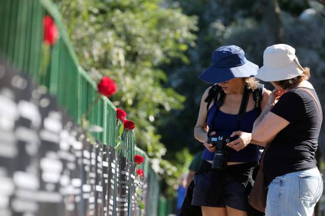 Turistas param para observar a homenagem feita aos 91 policiais mortos em serviço este ano pela ONG Rio de Paz, na Lagoa Rodrigo de Freitas - 25/07/2017 Turistas param para observar a homenagem feita aos 91 policiais mortos em serviço este ano pela ONG Rio de Paz, na Lagoa Rodrigo de Freitas - 25/07/2017