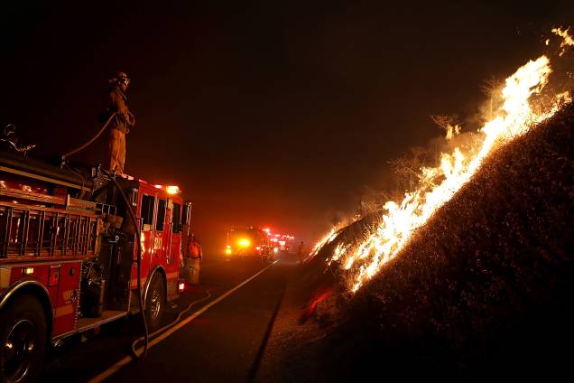 De cima do caminhão, um bombeiro monitora o fogo do incêndio Detwiler que já devastou mais de 25 mil hectares e forçou centenas de pessoas a evacuar suas casas na cidade de Mariposa, Califórnia De cima do caminhão, um bombeiro monitora o fogo do incêndio Detwiler que já devastou mais de 25 mil hectares e forçou centenas de pessoas a evacuar suas casas na cidade de Mariposa, Califórnia