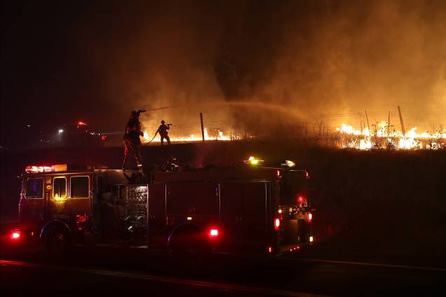 Bombeiros jogam água para conter o incêndio Detwiler em Mariposa, Califórnia. Mais de 1.400 bombeiros estão lutando contra o fogo que queimou mais de 25 mil hectares e forçou centenas de pessoas a evacuar suas casas Bombeiros jogam água para conter o incêndio Detwiler em Mariposa, Califórnia. Mais de 1.400 bombeiros estão lutando contra o fogo que queimou mais de 25 mil hectares e forçou centenas de pessoas a evacuar suas casas