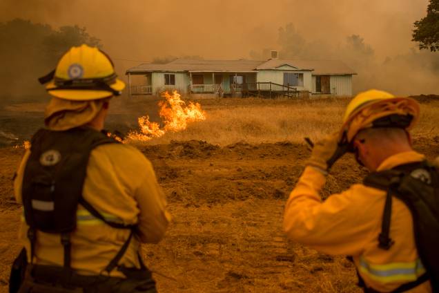 Bombeiros assistem às chamas do incêndio Detwiler, em Mariposa, que cercam uma casa na Califórnia Bombeiros assistem às chamas do incêndio Detwiler, em Mariposa, que cercam uma casa na Califórnia