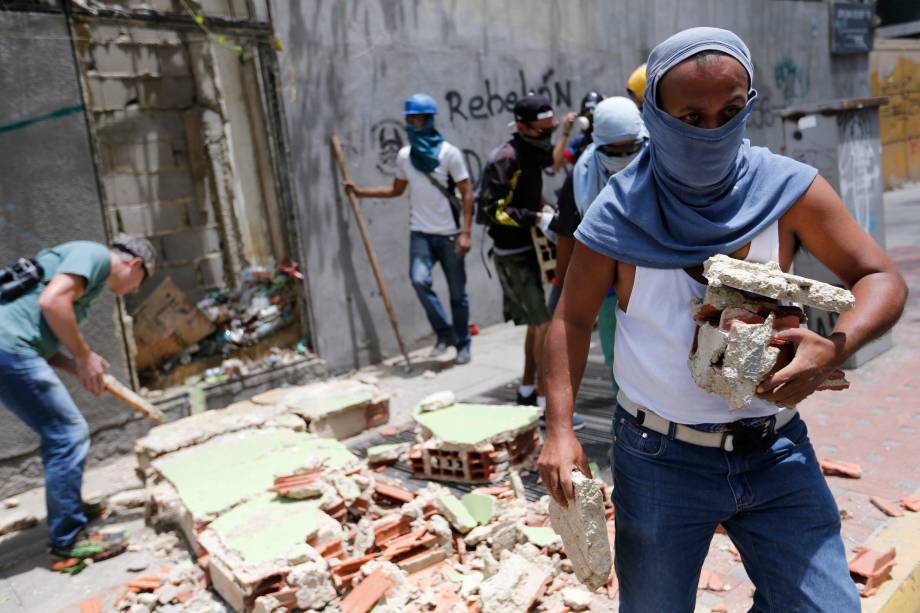 Manifestantes de oposição usam pedras durante confronto com a polícia em Caracas, na Venezuela - 30/07/2017