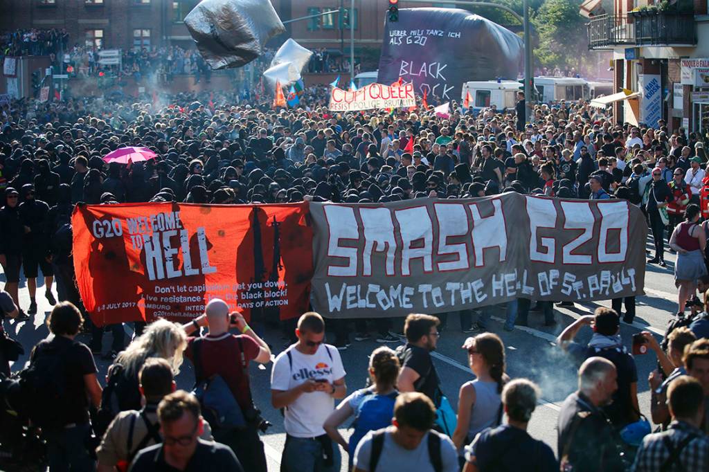 Manifestantes levantam cartazes para protestar contra a confer&ecirc;ncia do G20, em que l&iacute;deres das maiores economias do mundo se re&uacute;nem para discutir assuntos como economia, pol&iacute;tica, meio ambiente, acordos de paz etc. - 06/07/2017