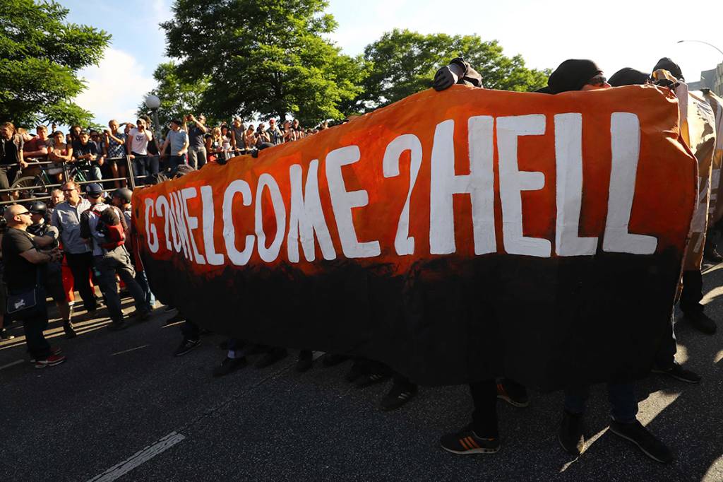 Manifestantes levantam cartazes para protestar contra a confer&ecirc;ncia do G20, em que l&iacute;deres das maiores economias do mundo se re&uacute;nem para discutir assuntos como economia, pol&iacute;tica, meio ambiente, acordos de paz etc. - 06/07/2017