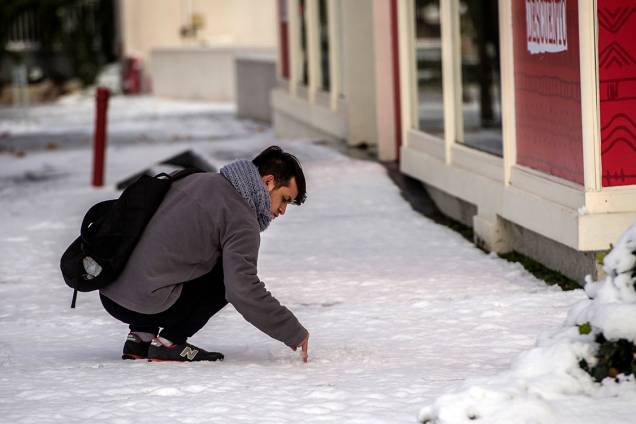 Pessoa se distrai com camada de neve no chão, após forte nevasca atingir a região de Santiago, no Chile - 15/07/2017 Pessoa se distrai com camada de neve no chão, após forte nevasca atingir a região de Santiago, no Chile - 15/07/2017