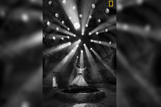 Feixes de luz entram pelos buracos de um edifício histórico em Konya, na Turquia, enquanto um derviche dança em função de uma jornada mística da ascensão espiritual do homem para a verdade e o amor, o ritual representa a revolução constante de todos os seres vivos Feixes de luz entram pelos buracos de um edifício histórico em Konya, na Turquia, enquanto um derviche dança em função de uma jornada mística da ascensão espiritual do homem para a verdade e o amor, o ritual representa a revolução constante de todos os seres vivos