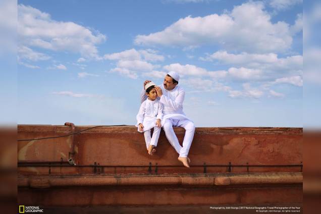 Em Nova Deli, na capital da Índia, pai e filho sentados em uma mesquita arrumam seus trajes tradicionais para o Eid al-Fitr, que marca o fim do jejum do Ramadã Em Nova Deli, na capital da Índia, pai e filho sentados em uma mesquita arrumam seus trajes tradicionais para o Eid al-Fitr, que marca o fim do jejum do Ramadã