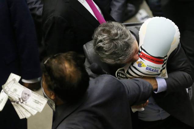 O deputado Paulo Teixeira (PT-SP) puxa e tenta furar com os dentes o pixuleco que estava com o deputado Wladimir Costa (SD-PA) O deputado Paulo Teixeira (PT-SP) puxa e tenta furar com os dentes o pixuleco que estava com o deputado Wladimir Costa (SD-PA)