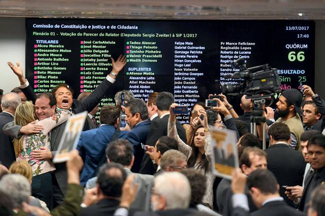 Brazilian deputies celebrate in the lower house's Constitution and Justice Committee the veto to the report authorizing the opening of the Supreme Court case against President Michel Temer, in Brasilia, , on July 13, 2017. Brazilian President Michel Temer looked on track Thursday to avoid trial over graft charges, after a committee of lawmakers recommended the accusations against him be shelved ahead of a congressional vote. / AFP PHOTO / EVARISTO SA