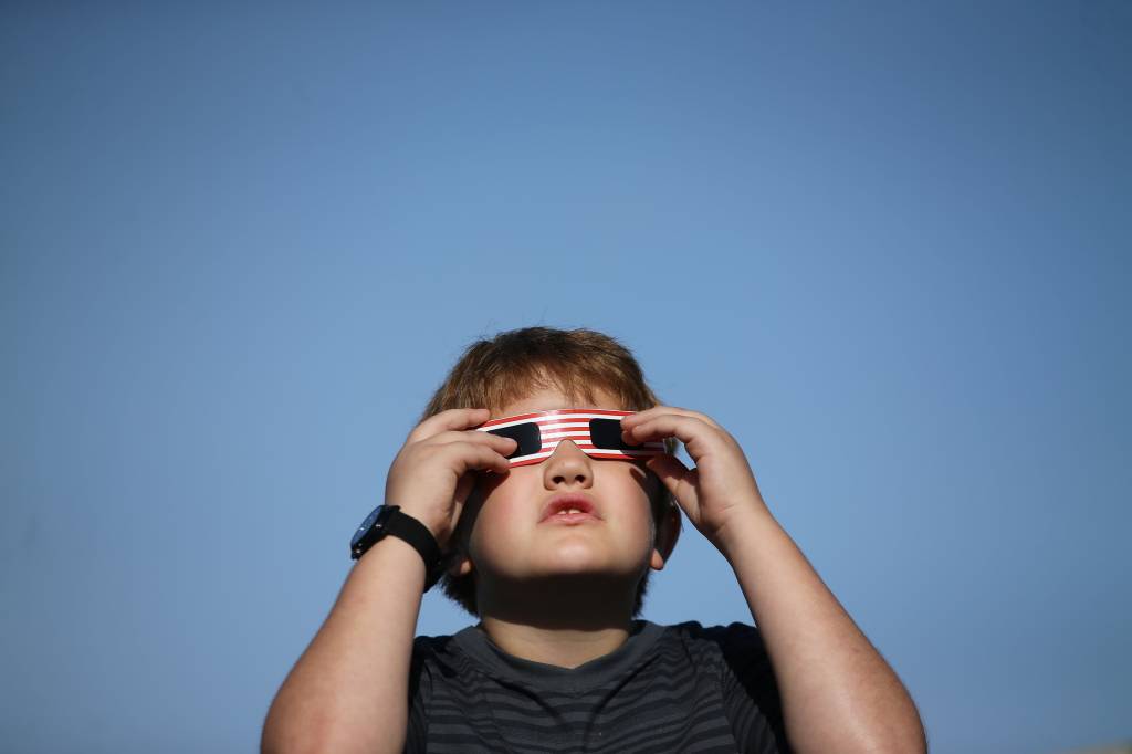 Menino usa &oacute;culos especial para acompanhar o eclipse solar em Depoe Bay, no estado americano do Oregon - 21/08/2017