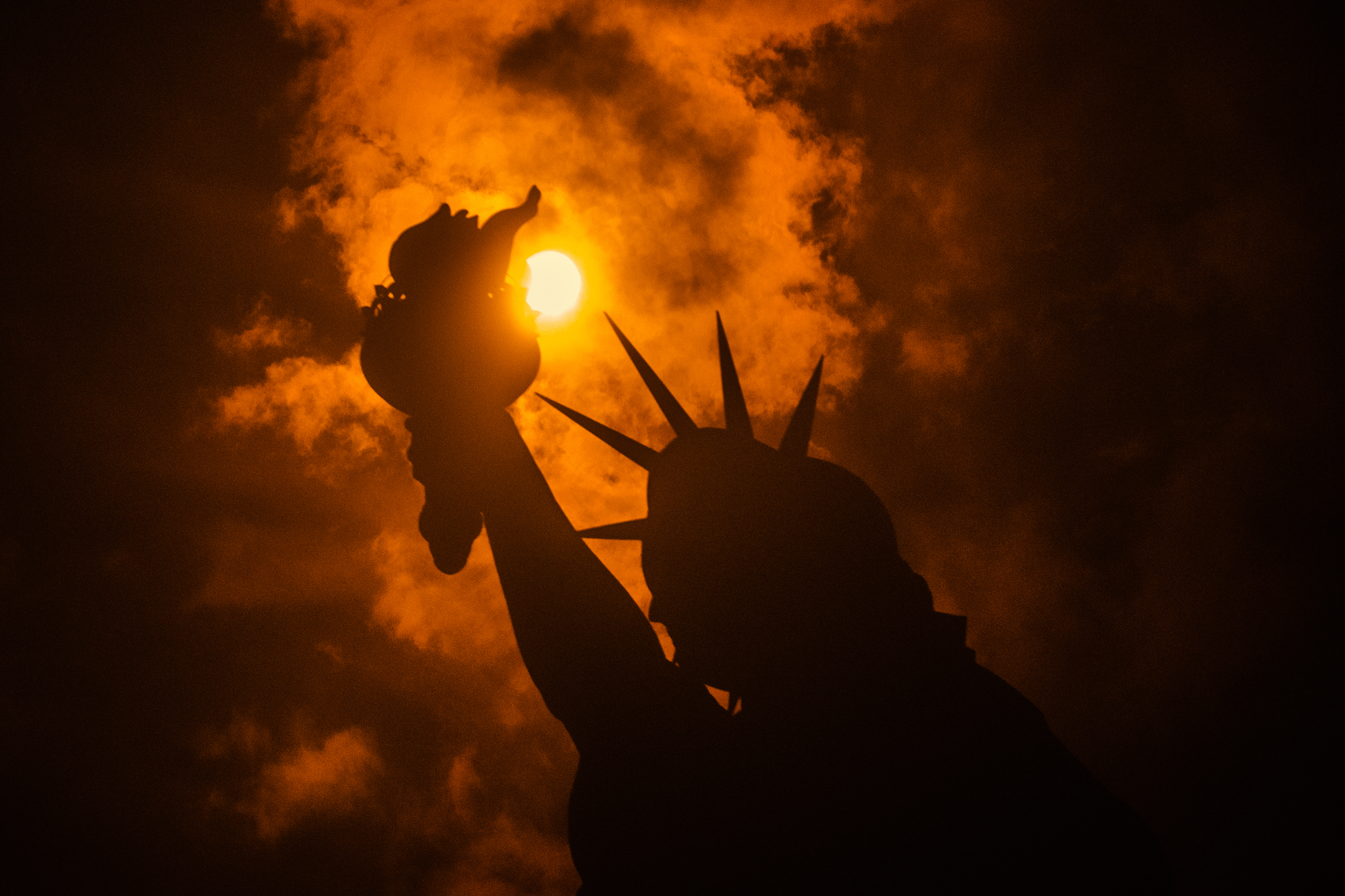 Eclipse solar &eacute; visto por tr&aacute;s da Est&aacute;tua da Liberdade em Liberty Island, na cidade de Nova York - 21/08/2017
