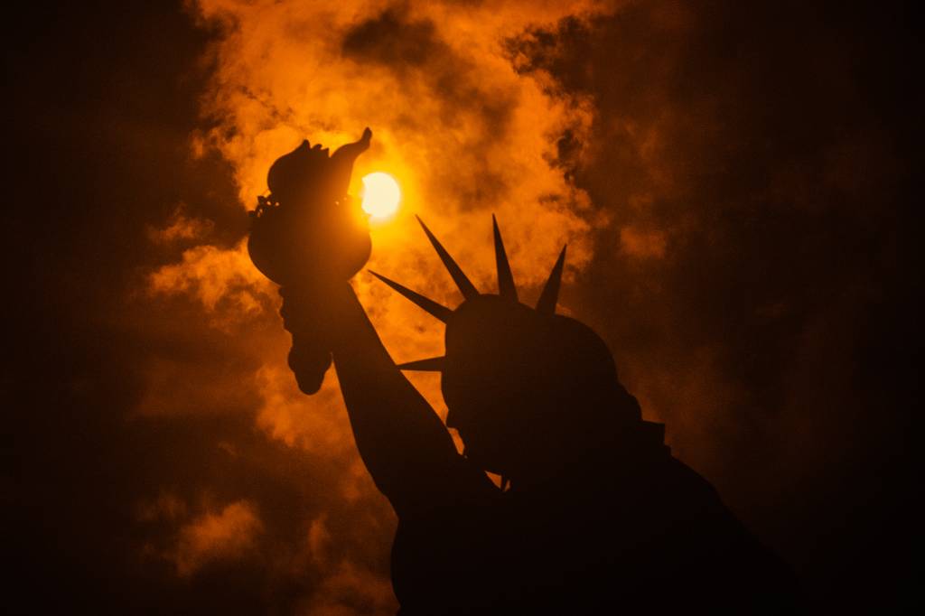 Eclipse solar &eacute; visto por tr&aacute;s da Est&aacute;tua da Liberdade em Liberty Island, na cidade de Nova York - 21/08/2017