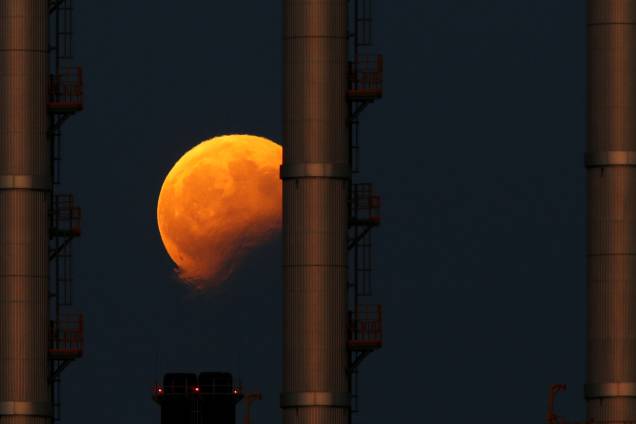O nascer da lua é fotografado durante o eclipse parcial atrás das chaminés de uma estação de energia elétrica em Delimara, fora da aldeia de Marsaxlokk, em Malta - 07/08/2017 O nascer da lua é fotografado durante o eclipse parcial atrás das chaminés de uma estação de energia elétrica em Delimara, fora da aldeia de Marsaxlokk, em Malta - 07/08/2017