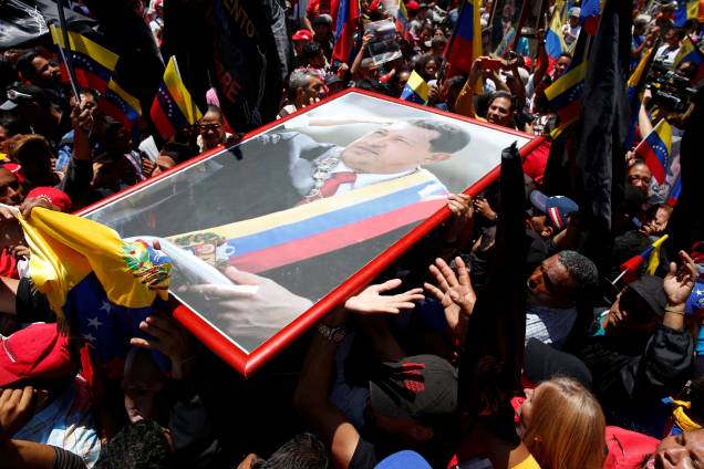 Partidários do ditador da Venezuela, Nicolás Maduro carregam um retrato de Hugo Chávez do lado de fora do Palácio Legislativo Federal durante a primeira sessão da Assembleia Nacional Constituinte, em Caracas - 04/08/2017 Partidários do ditador da Venezuela, Nicolás Maduro carregam um retrato de Hugo Chávez do lado de fora do Palácio Legislativo Federal durante a primeira sessão da Assembleia Nacional Constituinte, em Caracas - 04/08/2017